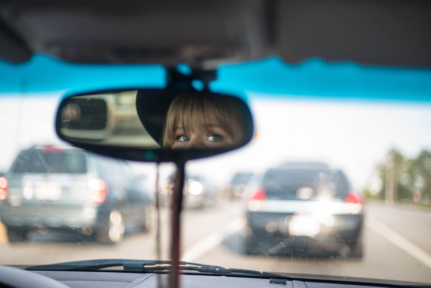 woman looking through rearview mirror