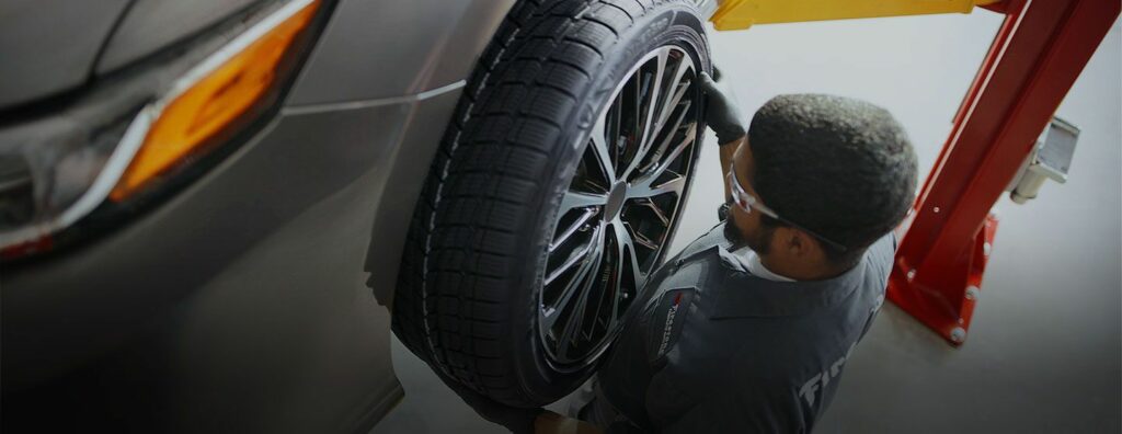 Person showing tire balancing on a car