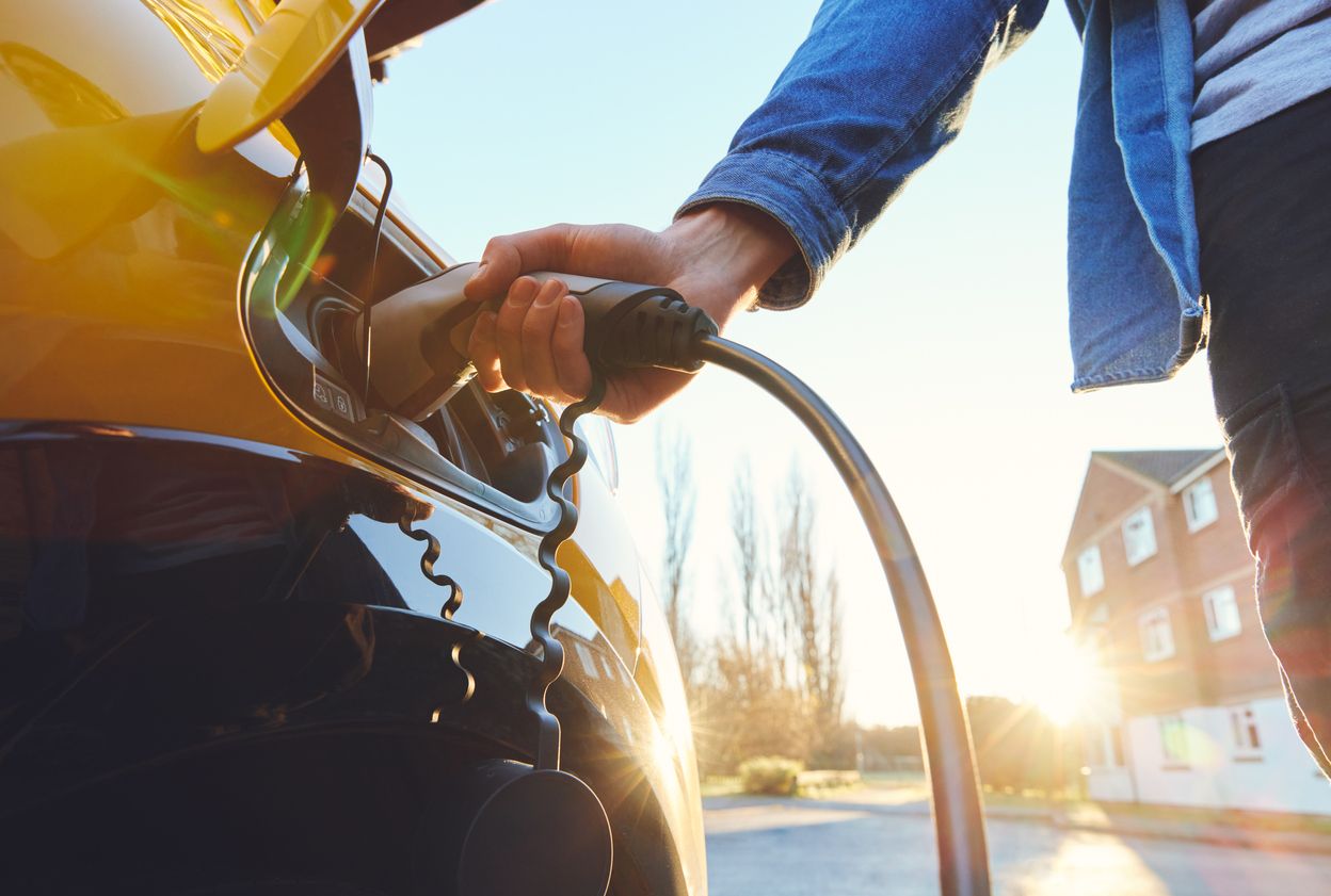 Electric car plugged in outside house stock photo