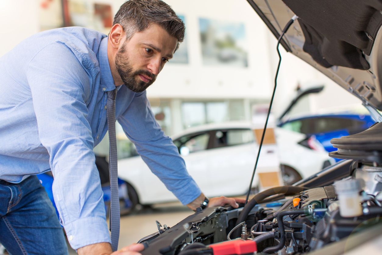 image of a man looking at car engine