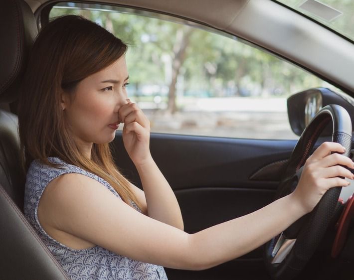 Women covering her nose while driving